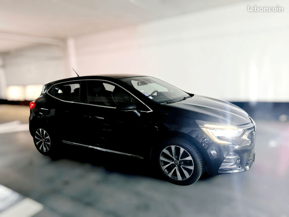 Renault Clio 5 noire, vue avant trois quarts, en parking couvert